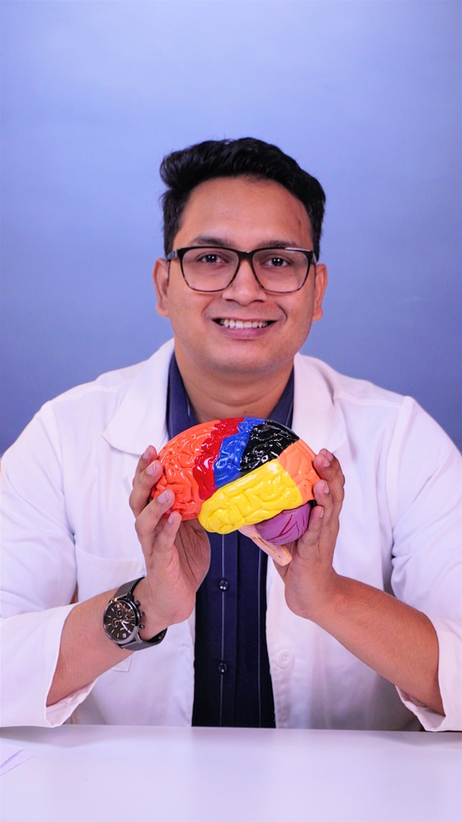 Dr. Abhijeet Holambe holding a brain model, psychiatrist in Malad West, Mumbai